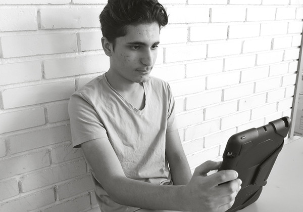 Ibrahim som sitter med läsplatta