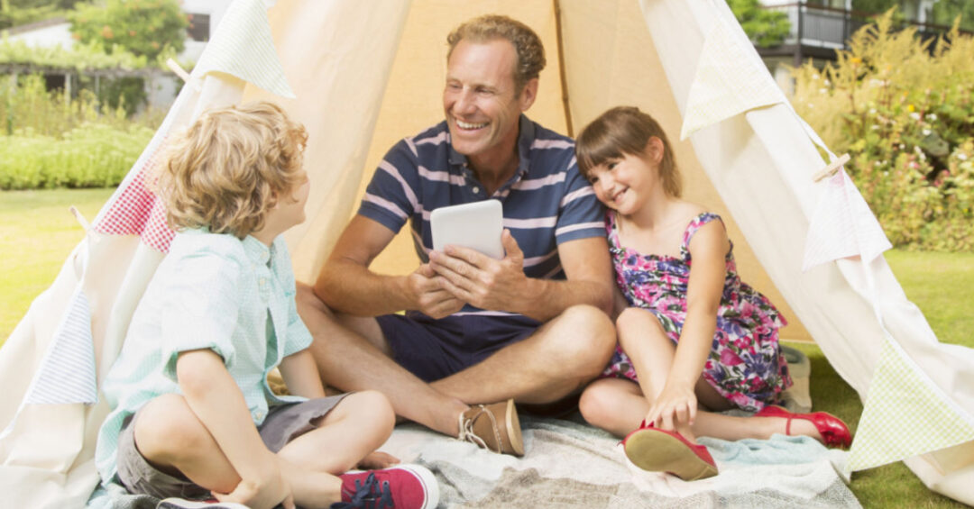 Un père lit un livre avec ses deux enfants
