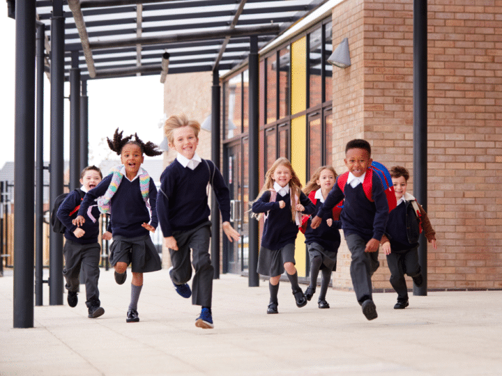 primary school children wearing school uniforms running at the camera