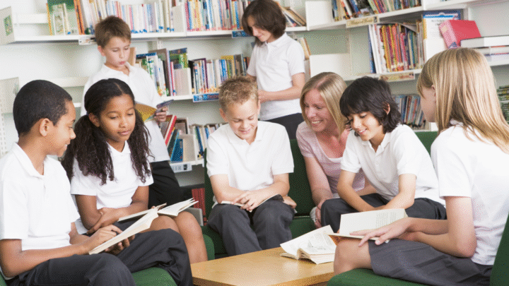 Group of primary school children in a library reading books