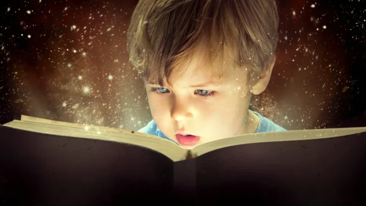young child reading a book. Magic coming off the pages